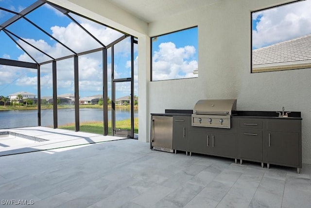 view of patio with a water view, area for grilling, a sink, exterior kitchen, and a lanai