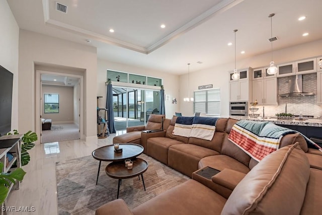 living area featuring a raised ceiling, recessed lighting, visible vents, and a wealth of natural light