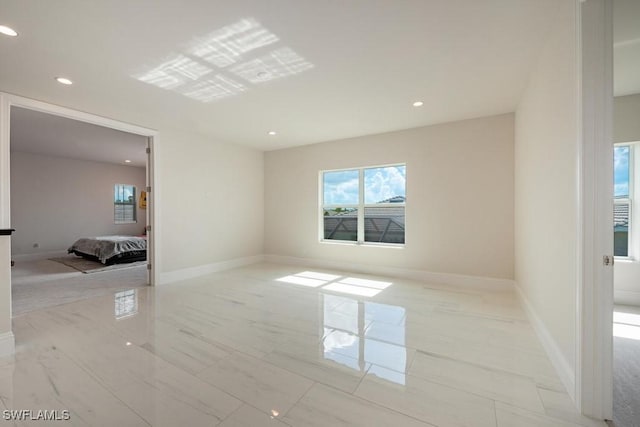 spare room with recessed lighting, baseboards, and marble finish floor