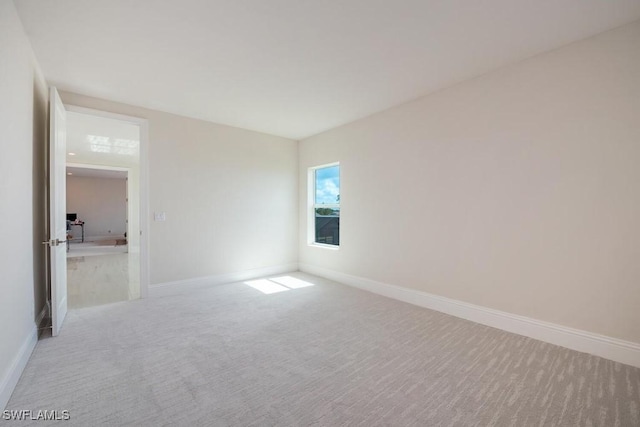 carpeted spare room featuring baseboards