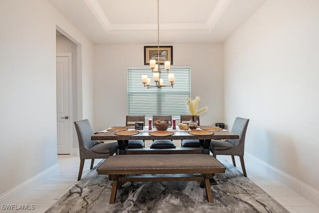 9121 Caicos Way, Naples, FL 34114 - dining space featuring a chandelier, a tray ceiling, and baseboards