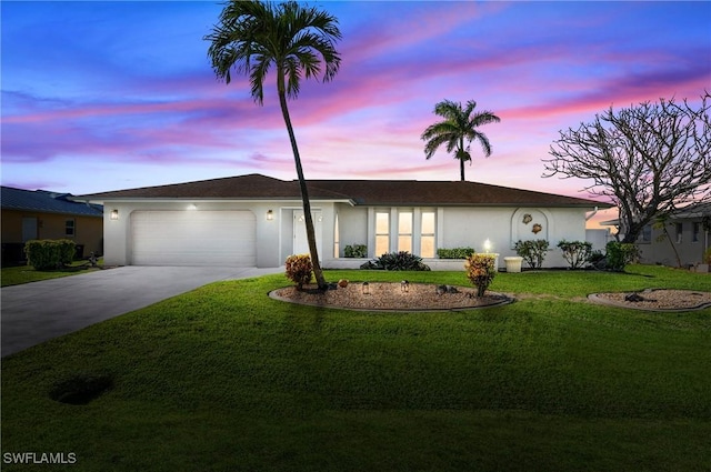 ranch-style home featuring stucco siding, a lawn, concrete driveway, and an attached garage