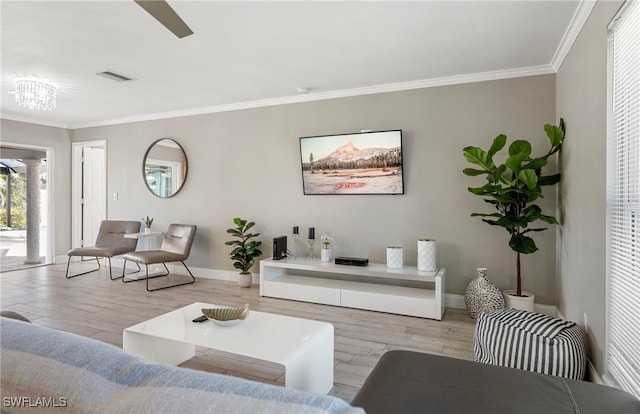 living area with visible vents, crown molding, baseboards, and wood finished floors