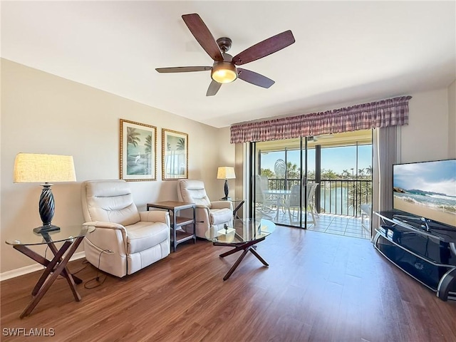 living room with baseboards, a ceiling fan, and wood finished floors