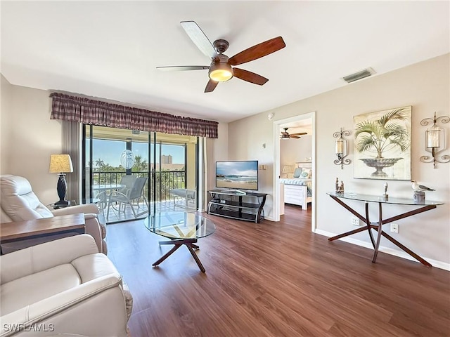 living room with wood finished floors, a ceiling fan, visible vents, and baseboards