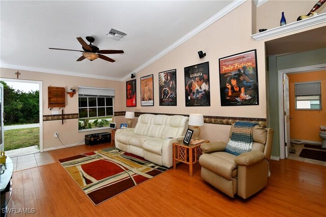 living room with visible vents, ornamental molding, wood finished floors, ceiling fan, and vaulted ceiling