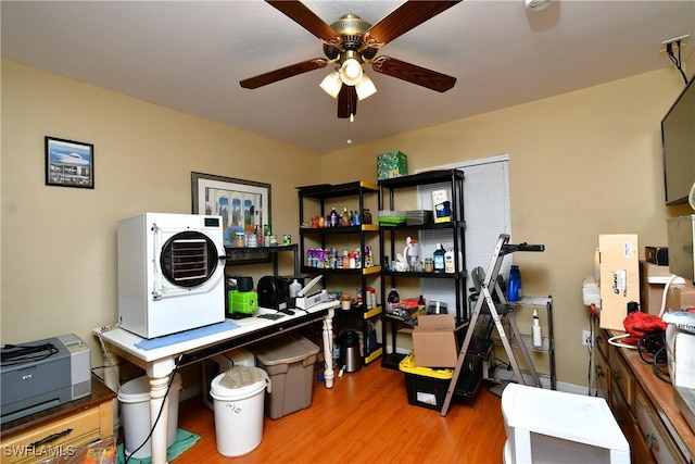 home office featuring washer / dryer, wood finished floors, and a ceiling fan