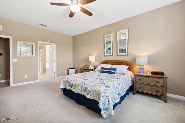 bedroom featuring visible vents, light colored carpet, baseboards, and ceiling fan