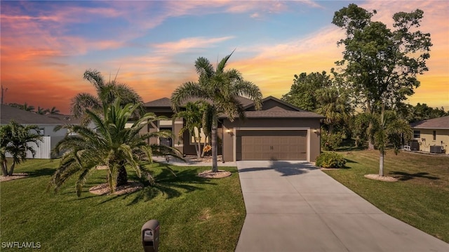 view of front facade with concrete driveway, an attached garage, a front yard, and stucco siding