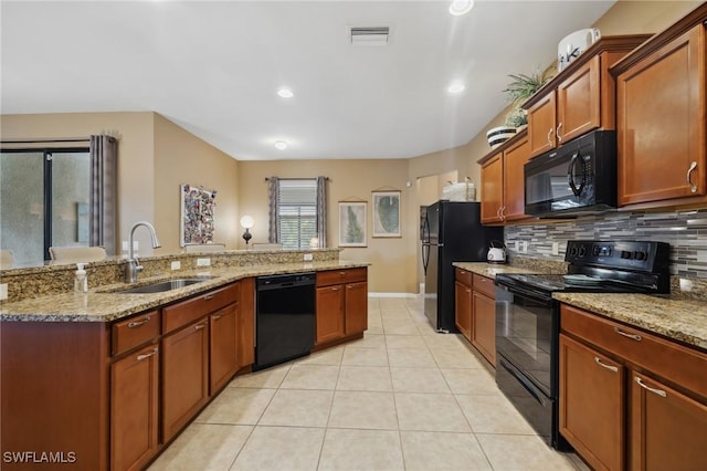 kitchen with visible vents, light tile patterned flooring, a sink, black appliances, and tasteful backsplash