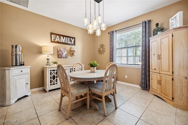 dining space featuring light tile patterned floors, visible vents, and baseboards