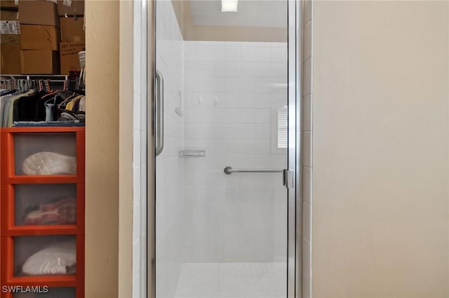 bathroom with a stall shower and a walk in closet