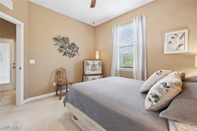 carpeted bedroom with visible vents, a ceiling fan, and baseboards