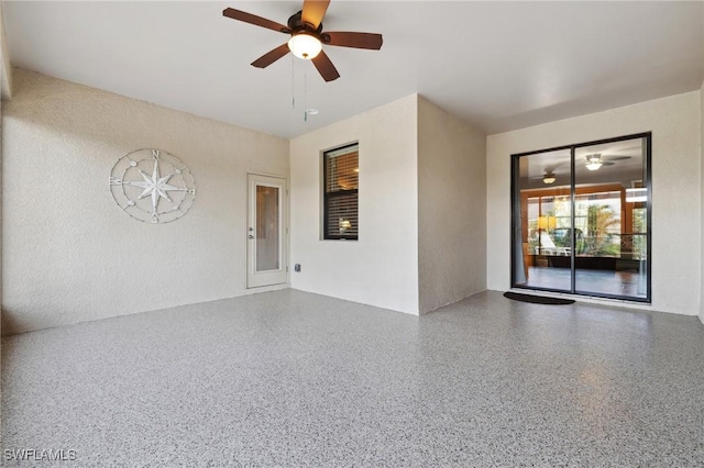 unfurnished room featuring a ceiling fan and speckled floor