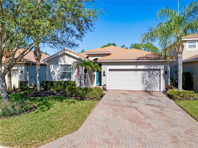21116 Bella Terra Blvd, Estero, FL 33928 - view of front of home featuring a tiled roof, a front yard, stucco siding, decorative driveway, and an attached garage