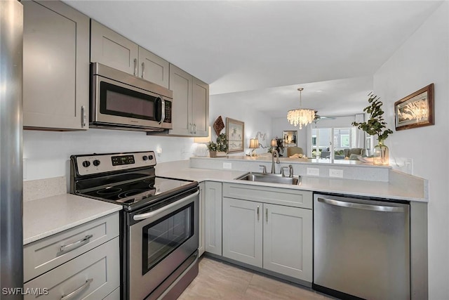 kitchen with gray cabinets, appliances with stainless steel finishes, light countertops, and a sink