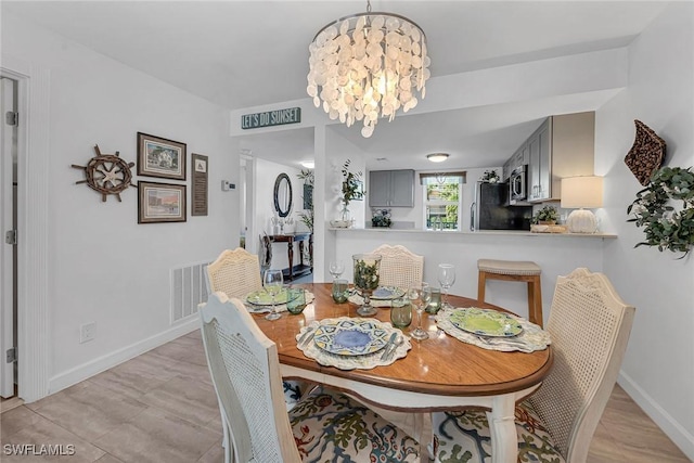 dining space with a notable chandelier, baseboards, and visible vents