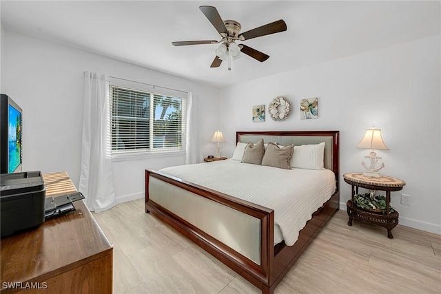 bedroom with ceiling fan, light wood-type flooring, and baseboards