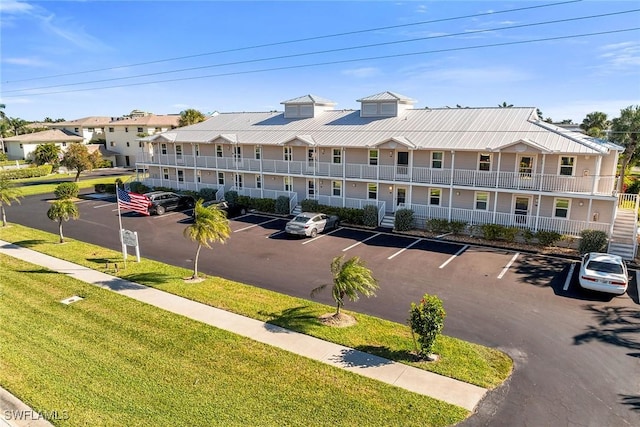 view of building exterior with uncovered parking and a residential view