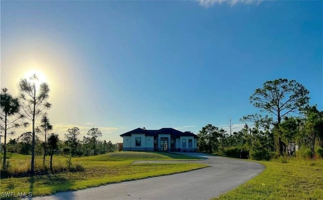 view of front of home featuring aphalt driveway and a front yard