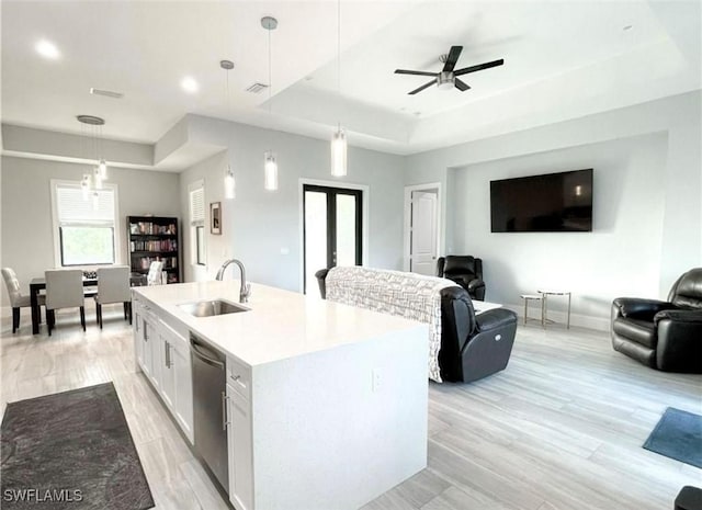 kitchen featuring a sink, hanging light fixtures, dishwasher, a raised ceiling, and open floor plan