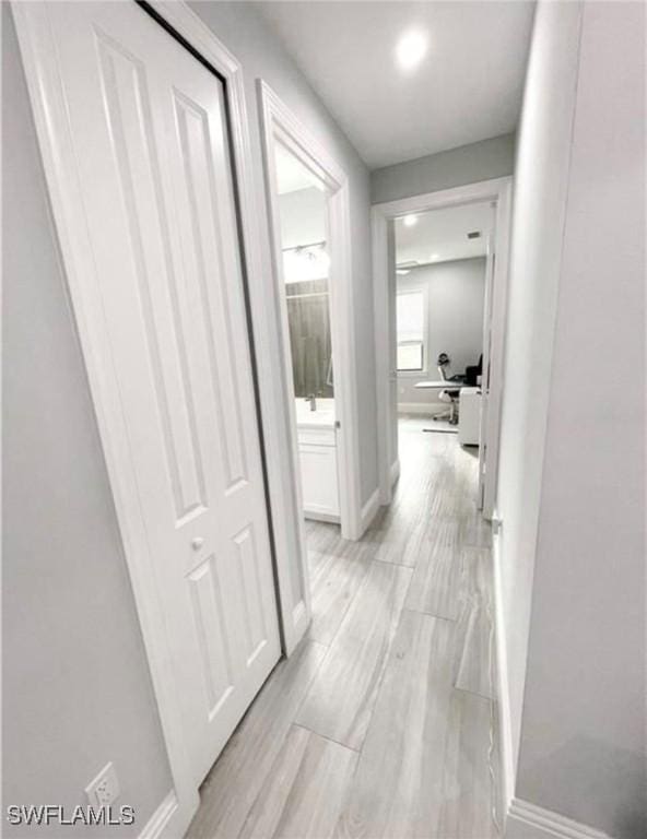 hallway with baseboards and wood finish floors