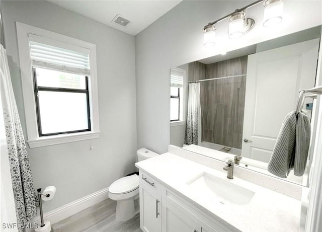 bathroom featuring visible vents, baseboards, toilet, a shower with shower curtain, and vanity