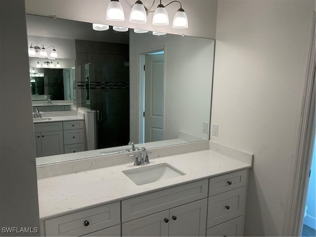 full bathroom featuring a shower stall, two vanities, and a sink