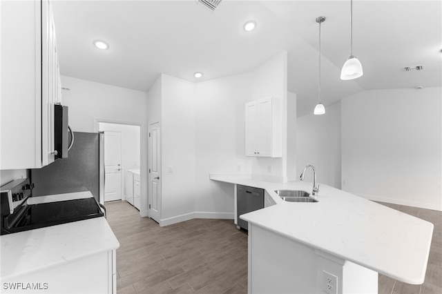 kitchen featuring visible vents, a peninsula, a sink, stainless steel appliances, and white cabinets