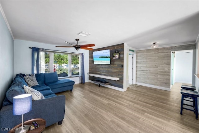 living area with ceiling fan, baseboards, wood finished floors, and crown molding