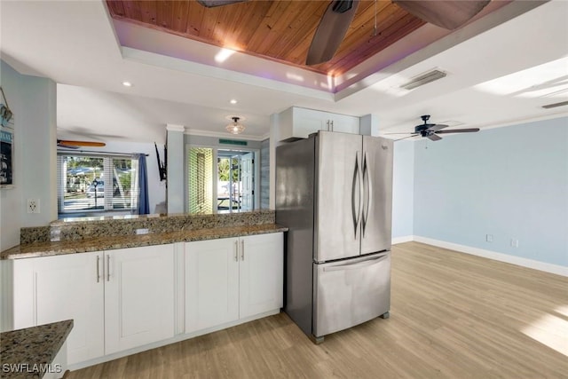 kitchen with visible vents, ceiling fan, wooden ceiling, freestanding refrigerator, and a raised ceiling