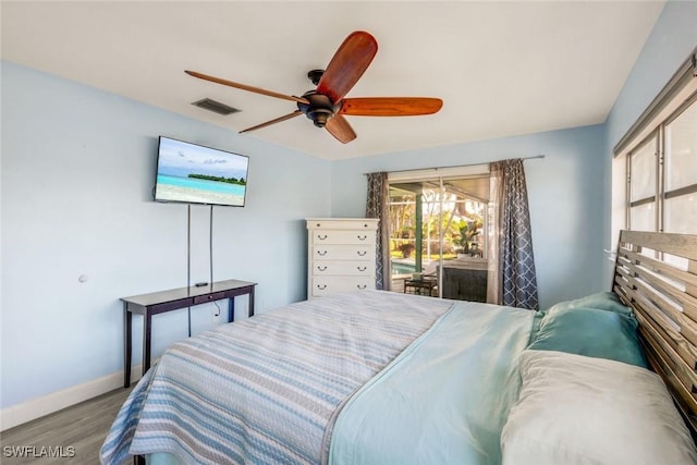 bedroom featuring access to exterior, visible vents, baseboards, wood finished floors, and a ceiling fan