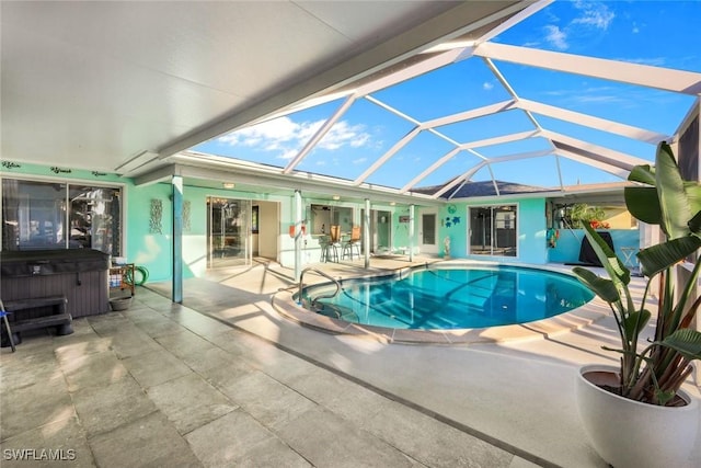 outdoor pool featuring a patio area, a lanai, and a hot tub