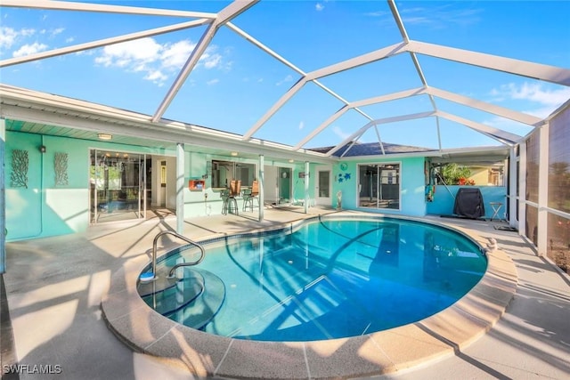 pool with a patio area and glass enclosure