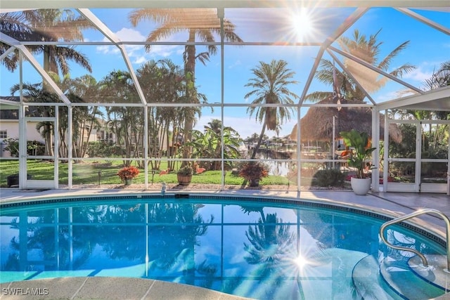 outdoor pool with glass enclosure and a patio