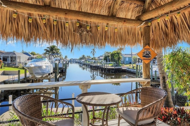 balcony with a water view, boat lift, and a boat dock