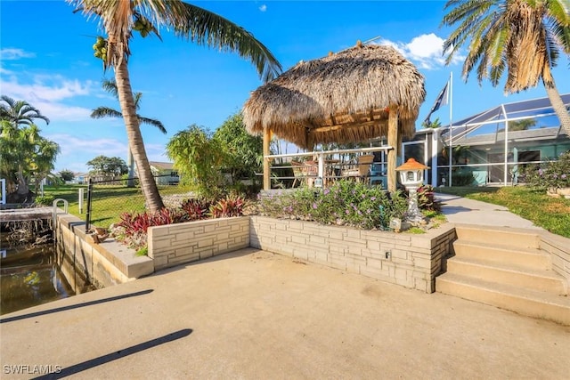 view of patio with glass enclosure and fence