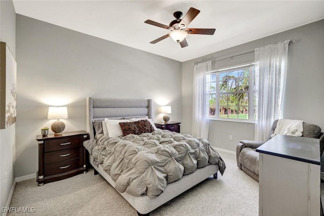 bedroom with a ceiling fan, light colored carpet, and baseboards