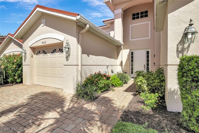 exterior space featuring an attached garage, driveway, and stucco siding