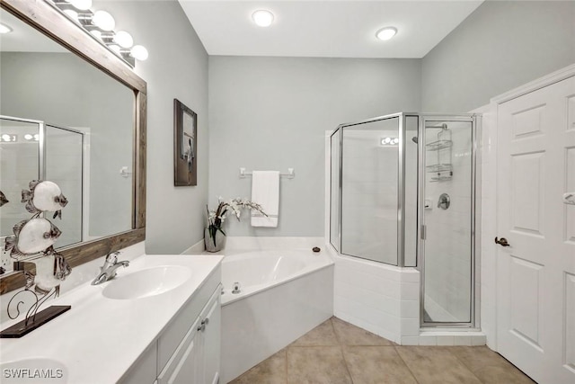 bathroom with tile patterned floors, a stall shower, a bath, and vanity