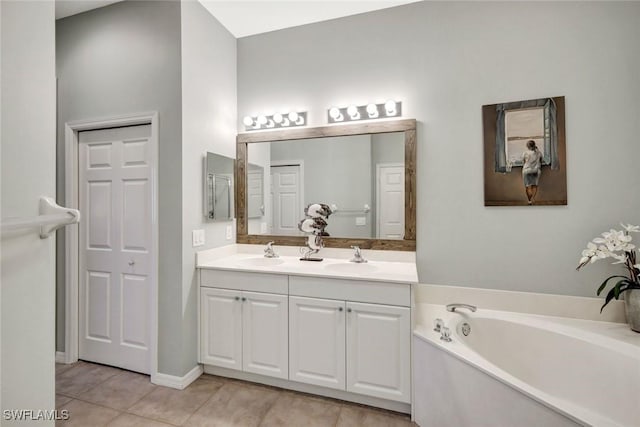 full bath featuring tile patterned flooring, a garden tub, double vanity, and a sink