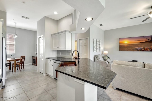 kitchen with visible vents, a ceiling fan, a sink, open floor plan, and a peninsula