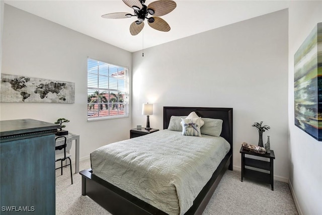 bedroom featuring light colored carpet, baseboards, and ceiling fan