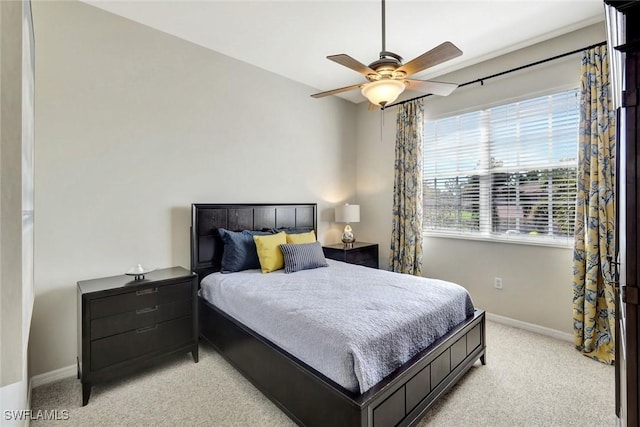 bedroom featuring light carpet, ceiling fan, and baseboards