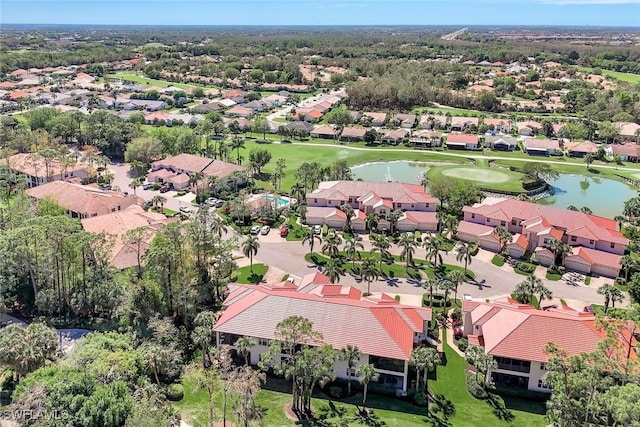 drone / aerial view featuring a residential view, golf course view, and a water view