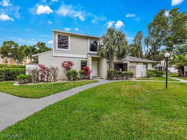 view of front of house featuring stucco siding and a front yard