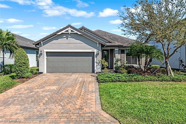 single story home with a front yard, decorative driveway, a garage, and stucco siding