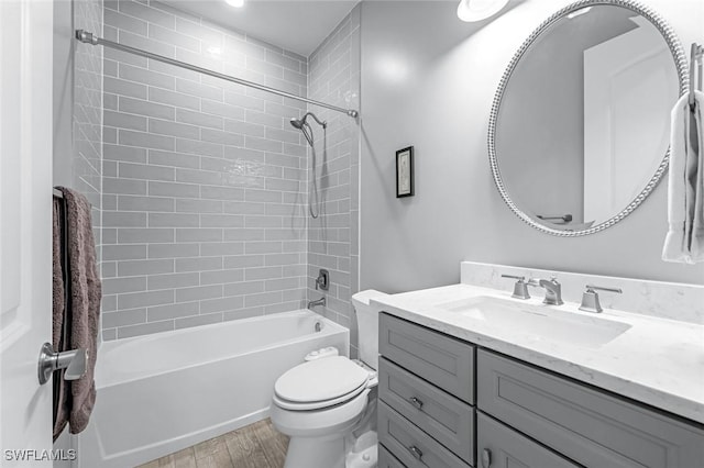 bathroom featuring vanity, toilet, wood finished floors, and shower / bathtub combination