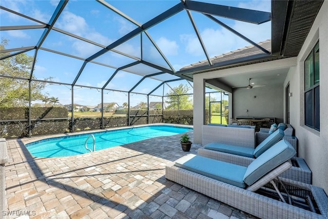 outdoor pool featuring glass enclosure and a patio area