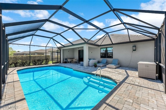 outdoor pool featuring glass enclosure and a patio area